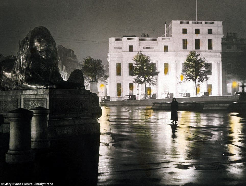Evocative: A woman cuts a solitary figure in the middle of Trafalgar Square at night in a photograph taken in 1910