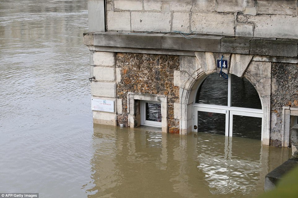 Paris regional authorities say the floods have already caused damage in 240 towns. In Villennes-sur-Seine west of Paris, the ground floor of some buildings has disappeared underwater and residents are using boats instead of cars. Pictured: Cafe 'Les Nautes' party submerged in the Seine 