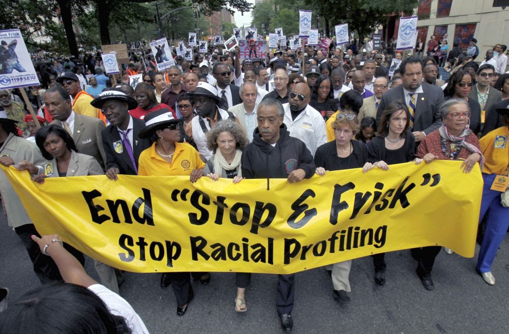 The Rev. Al Sharpton, center, walks with demonstrators June 17, 2012, during a silent march to end the "stop-and-frisk" program in New York. (Seth Wenig/AP)