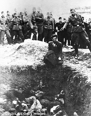 A member of the German S. S. Einsatz Gruppen D prepares to shoot a Polish Jew who is kneeling on the edge of a mass grave almost filled with previous victims