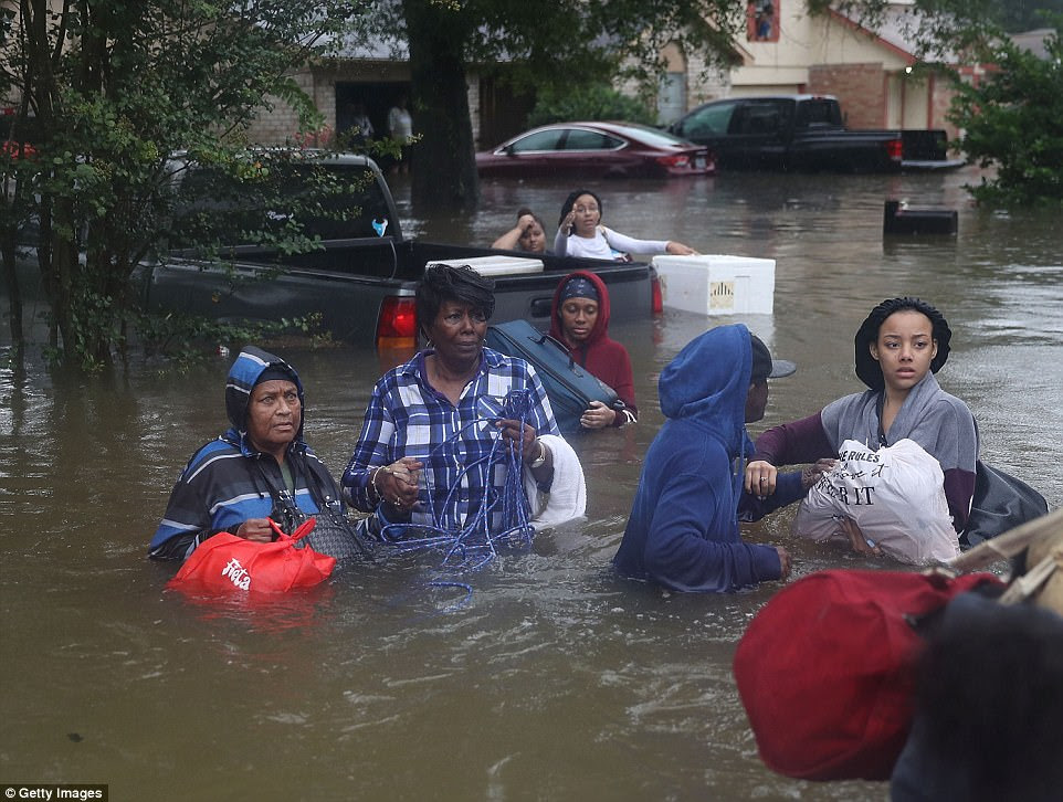 Residents flee their homes in Houston on Monday as flood waters continue to rise in parts of the city 