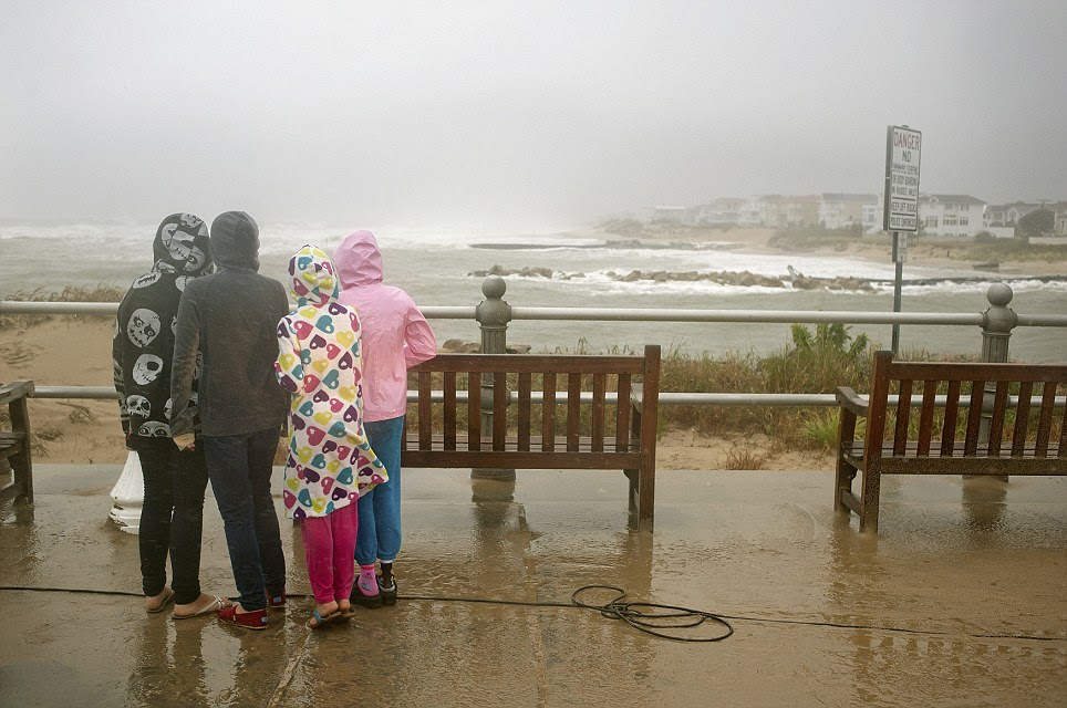 People take a walk along the beach as high winds and heavy rain from Hurricane Sandy arrive in Virginia Beach, Virginia this morning 