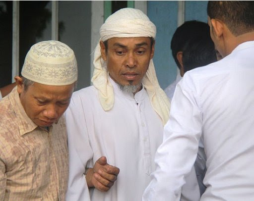 A 48-year-old Indonesian man named Bantil (C) is escorted from his residence on December 10, 2012