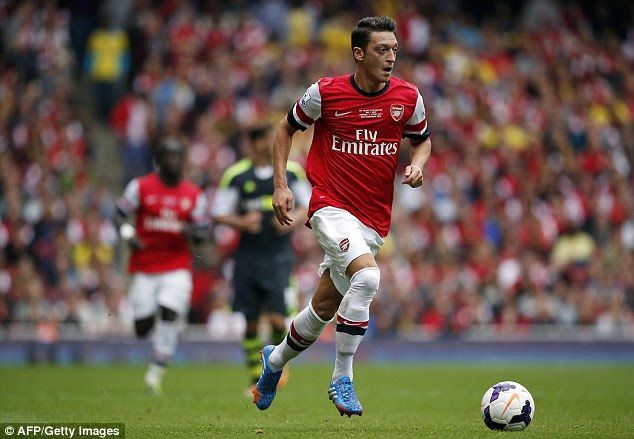 On the run: Mesut Ozil drives forward for Arsenal against Stoke