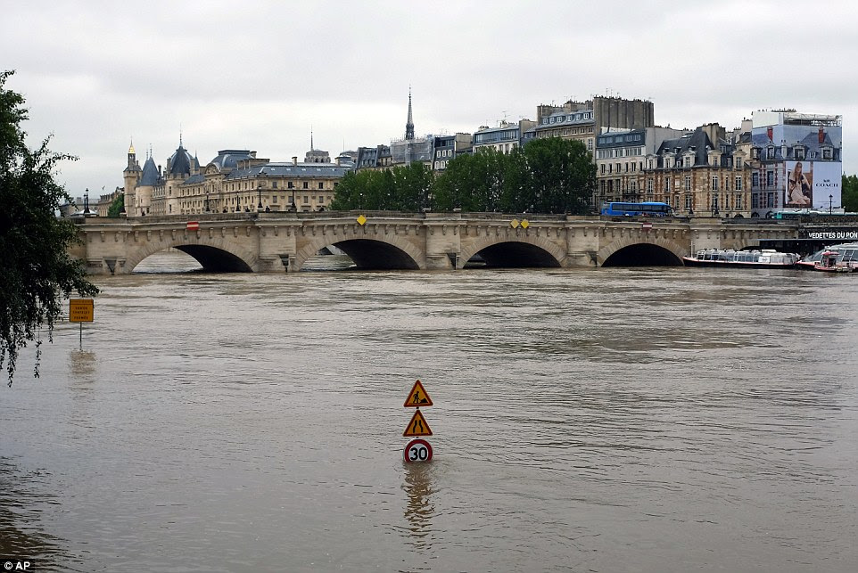 A traffic sign stands in a flooded road in Paris. Both the Louvre and Orsay museums were closed as the Seine, which officials said was at its highest level in nearly 35 years, was expected to peak sometime later today