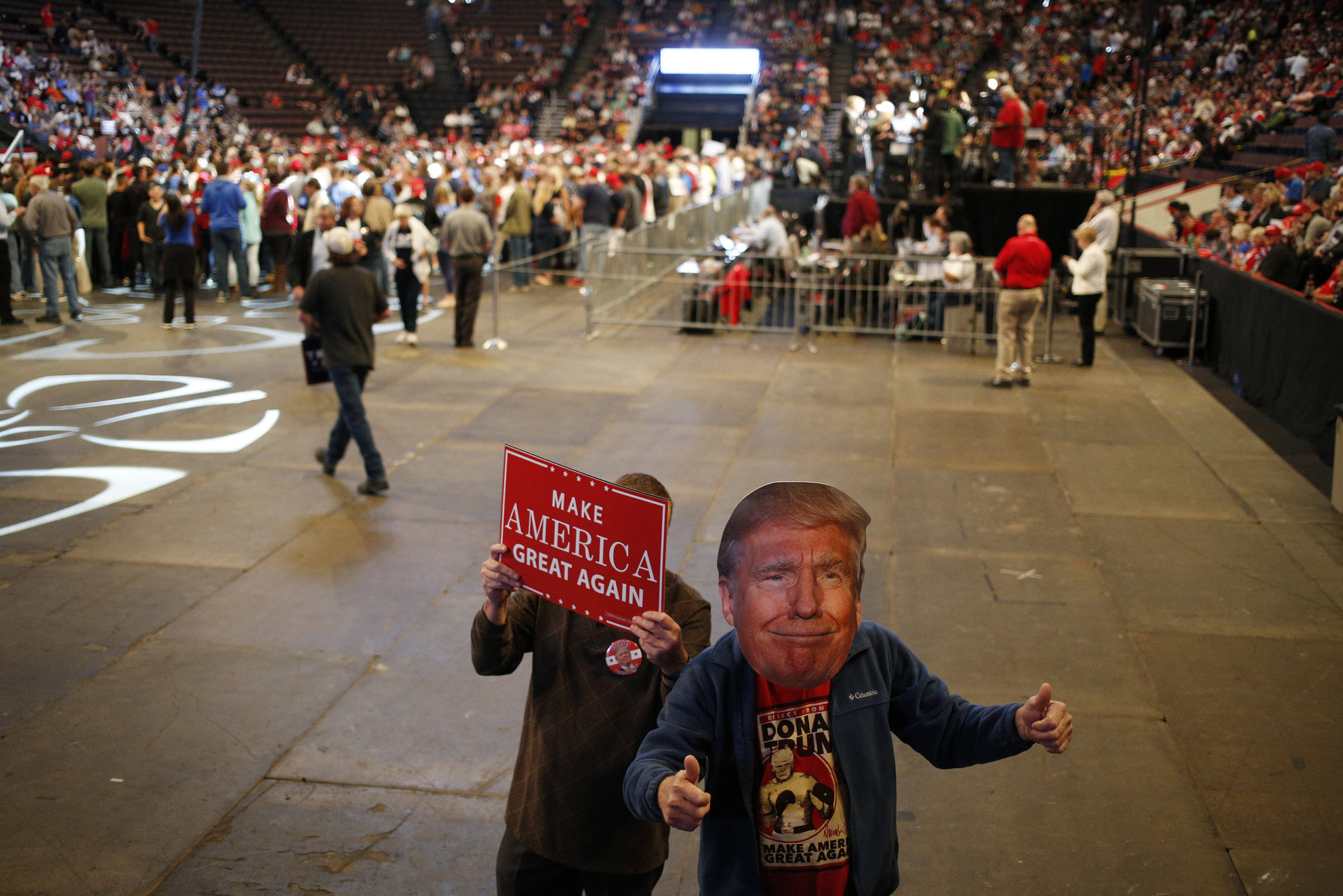 gAn attendee gives the thumbs up while wearing a Donald Trump mask during a campaign event for Donald Trump, 2016 Republican presidential nominee, in Cincinnati, Ohio, U.S., on Thursday, Oct. 13, 2016. Trump rebuffed political aides' requests to research his past, people familiar with the matter said, a decision that contributed to his campaign being caught unprepared for the past week's barrage of claims he mistreated women. Photographer: Luke Sharrett/Bloomberg