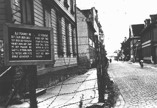 A sign, in both German and Latvian, warning that people attempting to cross the fence or to contact inhabitants of the Riga ghetto will be shot. Riga, Latvia, 1941-1943.