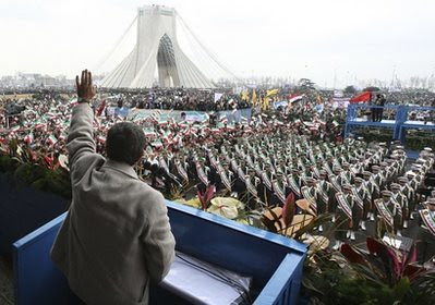 Iranian President Mahmoud Ahmadinejad, waves to the crowd in a rally marking the 32nd anniversary of the 1979 Islamic Revolution, at the Azadi (Freedom)Square, in Tehran, Iran, Friday, Feb. 11, 2011, while the Azadi monument tower is seen in background.  by Pan-African News Wire File Photos