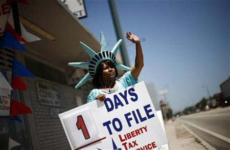 A woman dressed as the Statue of Liberty waves to attract people to a tax office in Miami April 14, 2008. REUTERS/Carlos Barria