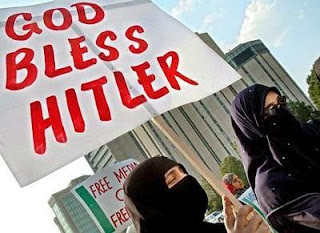 Photo: niqab-clad Muslim women holding a sign that says, "God Bless Hitler" (accursed be those who think such evil thoughts)