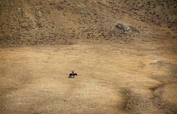 A herder rides a horse on grasslands located southwest of the Mongolian capital city Ulan Bator, April 4, 2012. REUTERS-David Gray
