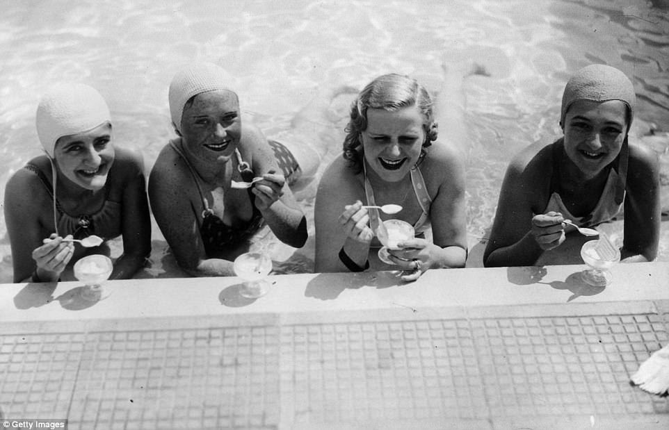 Four swimmers enjoy an ice-cream at the water's edge in Roehampton swimming pool in May 1936