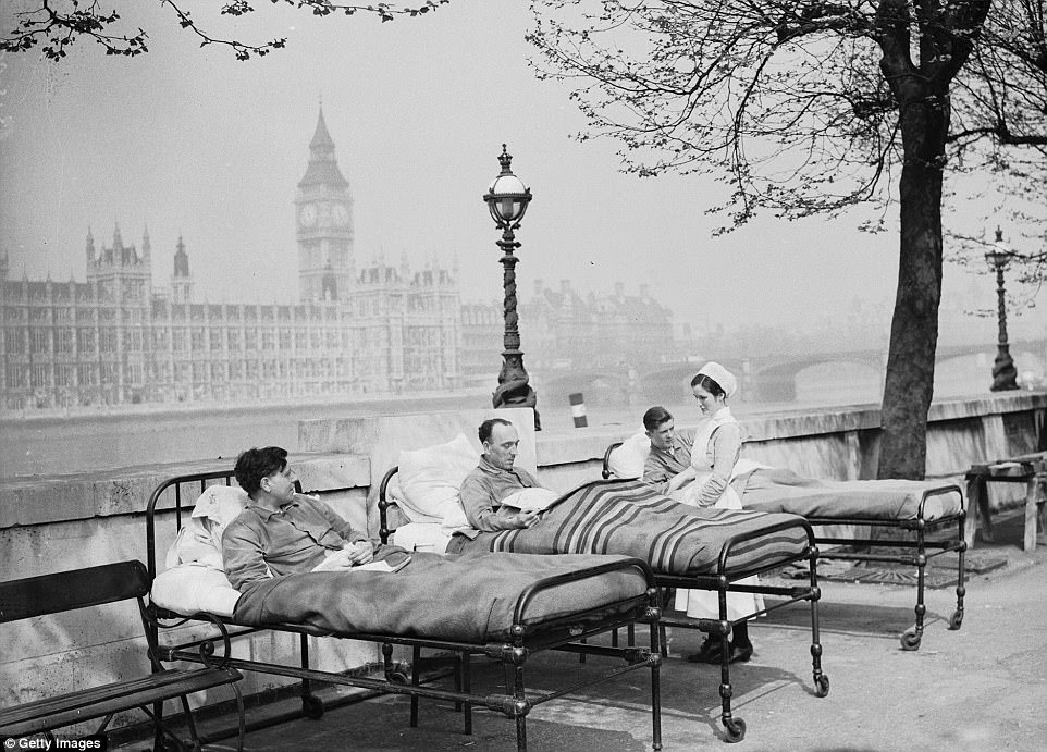 Tuberculosis patients from St. Thomas' Hospital rest in their beds in the open air by the River Thames, opposite the Houses of Parliament, in May 1936