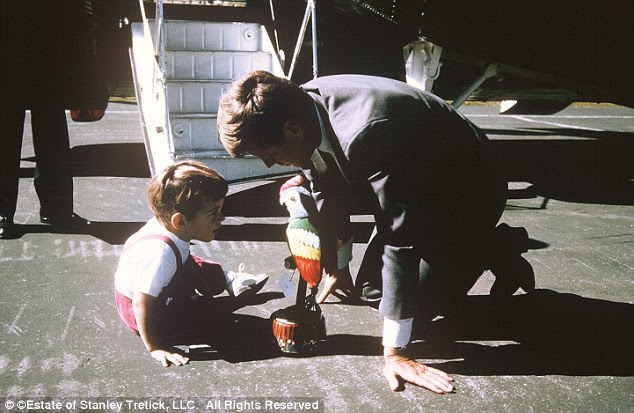Time out: JFK plays with his son John before boarding a flight on Marine One flanked by members of the Secret Service