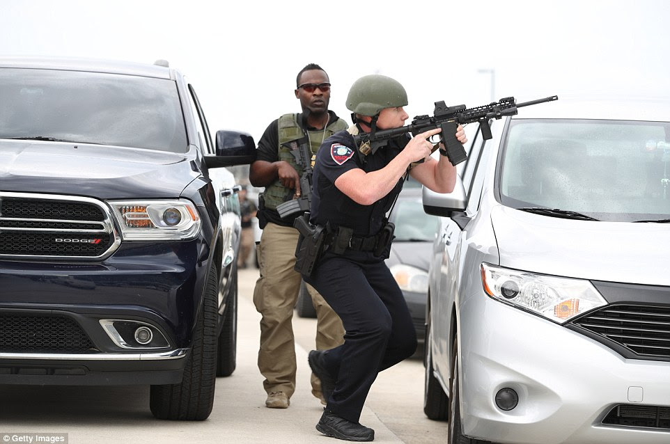 Law enforcement personnel stand near the airport on Friday