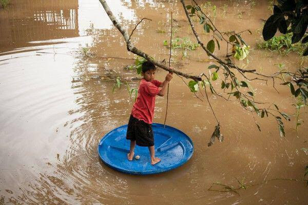 A young boy plays in the Amazon river.