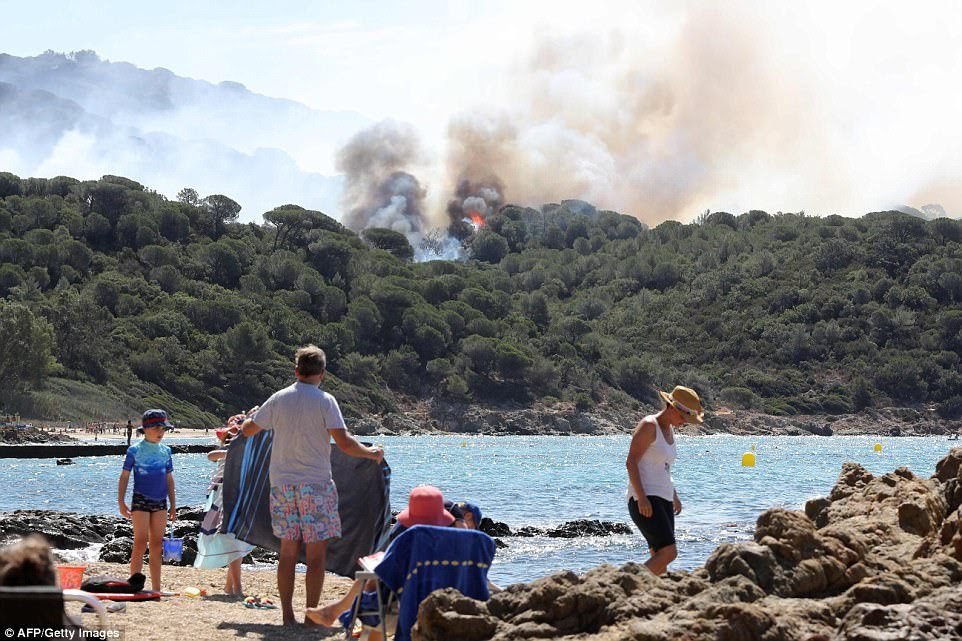 Tourists seemed unconcerned and continued to enjoy the beaches near Saint-Tropez as forest fires swept through nearby woodland