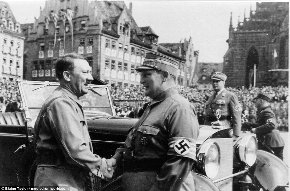 Goering is greeted by his Führer at Hitler's Mercedes-Benz 770K Grosser open touring car that annually served as the reviewing stand on Adolf Hitler Plaza yearly between 1933-38