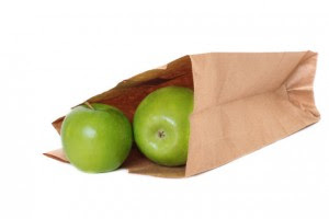 Green apples in a paper bag isolated