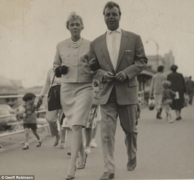 A couple stroll down the promenade in Skegness in 1961. The woman wears a matching skirt and jacket, with heels, gloves and a pearl necklace while the man opts for a suit and tie