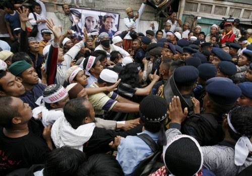 Indonesian hardliner Muslims clash with policemen as the dead bodies of Bali bombers Amrozi and Muklas alias Ali Gufron arrive at Tenggulun village near Lamongan, East Java province November 9, 2008. Thousands of people including some hardliners gathered for the funerals of three Indonesians executed on Sunday for the 2002 Bali bombings, sparking clashes between police and emotional supporters. REUTERS/Beawiharta (INDONESIA)