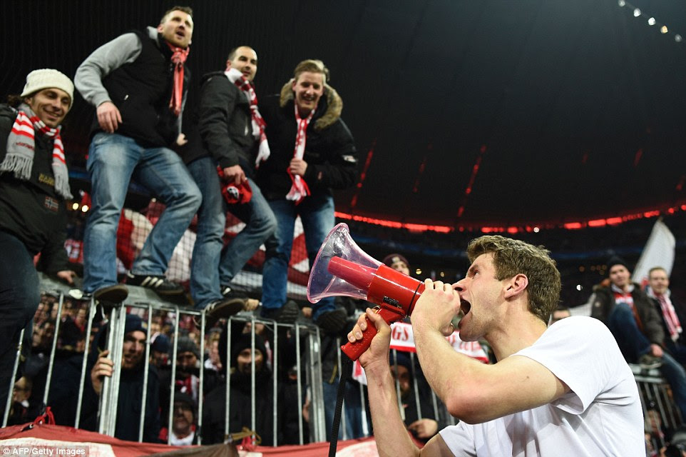Bayern hero Muller celebrates with supporters and shouts into a megaphone after the German side secured their place in the last eight