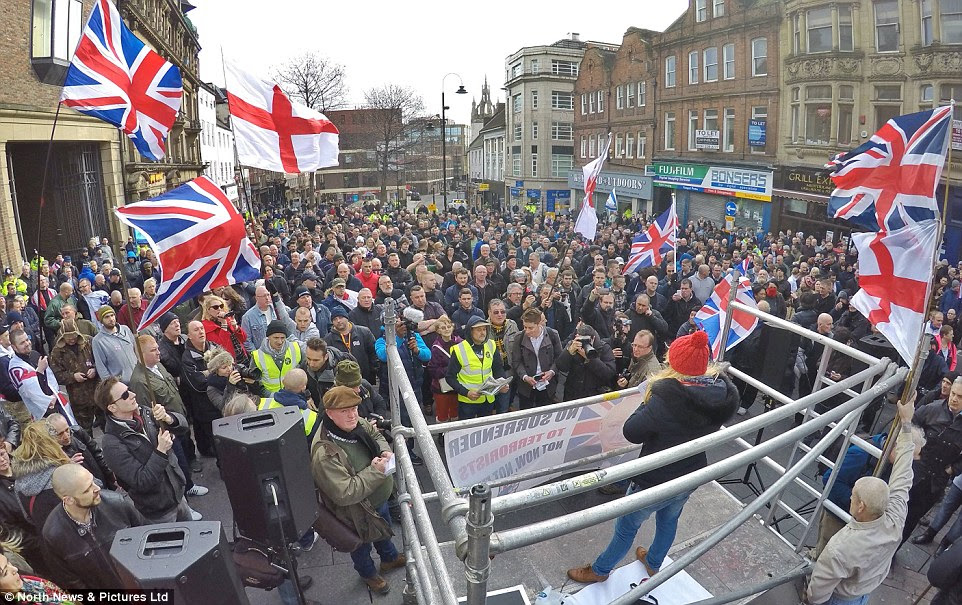 Flags of England and the United Kingdom fly as a woman address the Pegida rally of around 400 far-right protesters 