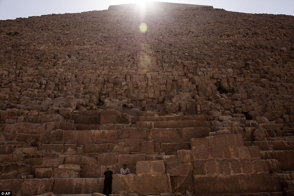 The sun's rays glint over the the top of the pyramid illuminating its many steps