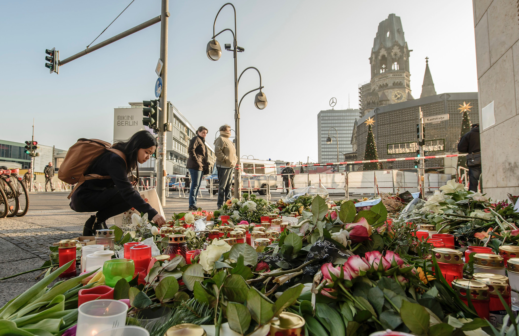 A mourner places a candle on December 21, 2016 at a makeshift memorial near the Kaiser-Wilhelm-Gedaechtniskirche (Kaiser Wilhelm Memorial Church) in Berlin, close to the site where a truck crashed into a Christmas market two days