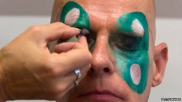 A man has his make-up applied at the London School of Samba