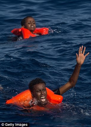 Refugees and migrants are seen swimming and yelling for assistance from crew members from the Migrant Offshore Aid Station (MOAS) 'Phoenix' vessel after a wooden boat bound for Italy carrying more than 500 people capsized on May 24, 2017 off Lampedusa, Italy