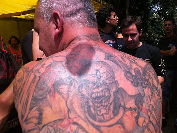  Marcos Motolo, de 40 anos, já é uma celebridade entre os fãs do Iron Maiden. Ele tem 172 tatuagens, todas com as capas e símbolos do grupo. Motolo entrou para o Guiness como o fã que tem mais tatuagens no mundo com os ideogramas da banda. A primeira tatuagem foi em 1999. Durante seis anos seguidos, ele passou 18 horas por dia desenhando a pele. Motolo veio de São Paulo para assistir ao show da banda e aguarda a abertura dos portões da Cidade do Rock, marcada para as 14h (Foto: Tássia Thum/G1)