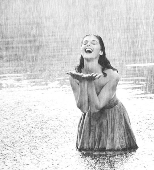 Pier Angeli, 22, clad in strapless chiffon party dress, exhulting in a downpour of rain as she stands knee deep in a woodland pond, photographed by Allan Grant for LIFE Magazine, 1954.