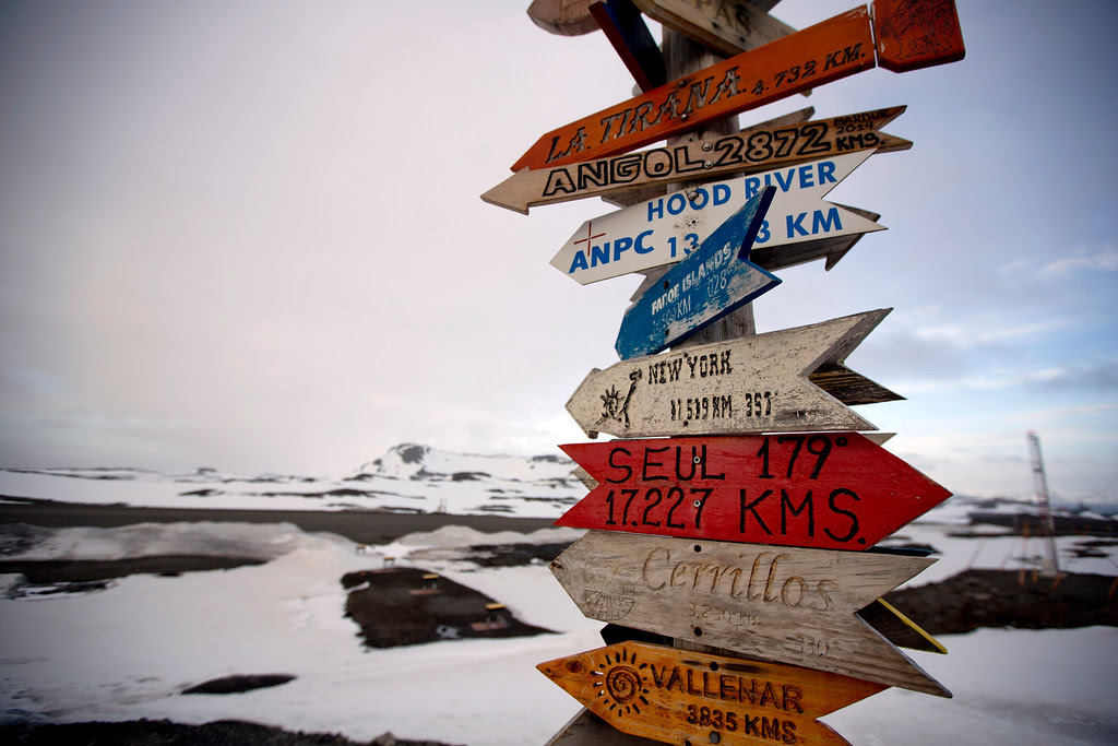 Description of . In this Jan. 20, 2015 photo, wooden arrows show the distances to various cities near Chile's Escudero station on King George Island, Antarctica. Thousands of scientists come to Antarctica for research. There are also non-scientists, chefs, divers, mechanics, janitors and the priest of the worldís southernmost Eastern Orthodox Church on top of a rocky hill at the Russian Bellinghausen station. (AP Photo/Natacha Pisarenko)