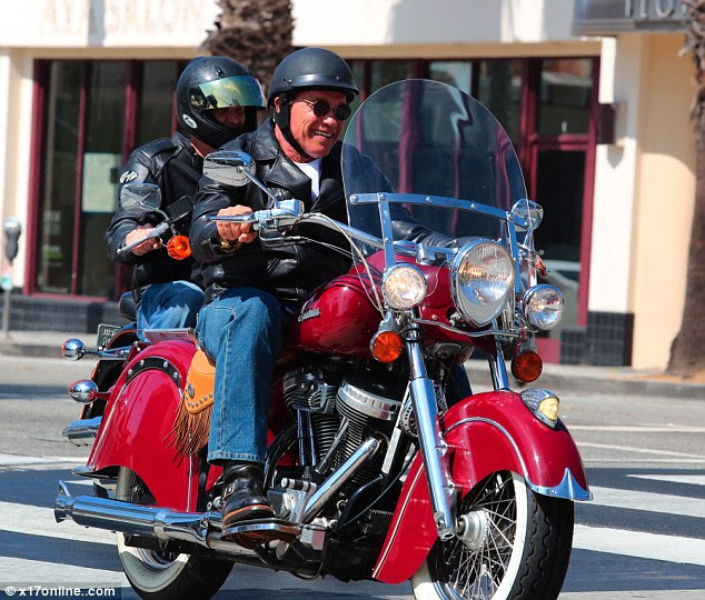 Happy day: Wearing a biker jacket, black helmet and sunglasses, the former California Governor was all smiles as he rode along