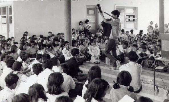 Nhạc sĩ Nguyễn Đức Quang (cầm đàn) trong một buổi sinh hoạt của nhóm Du Ca với các học sinh trường Trung Học Kiểu Mẫu Thủ Đức vào cuối thập niên 1960