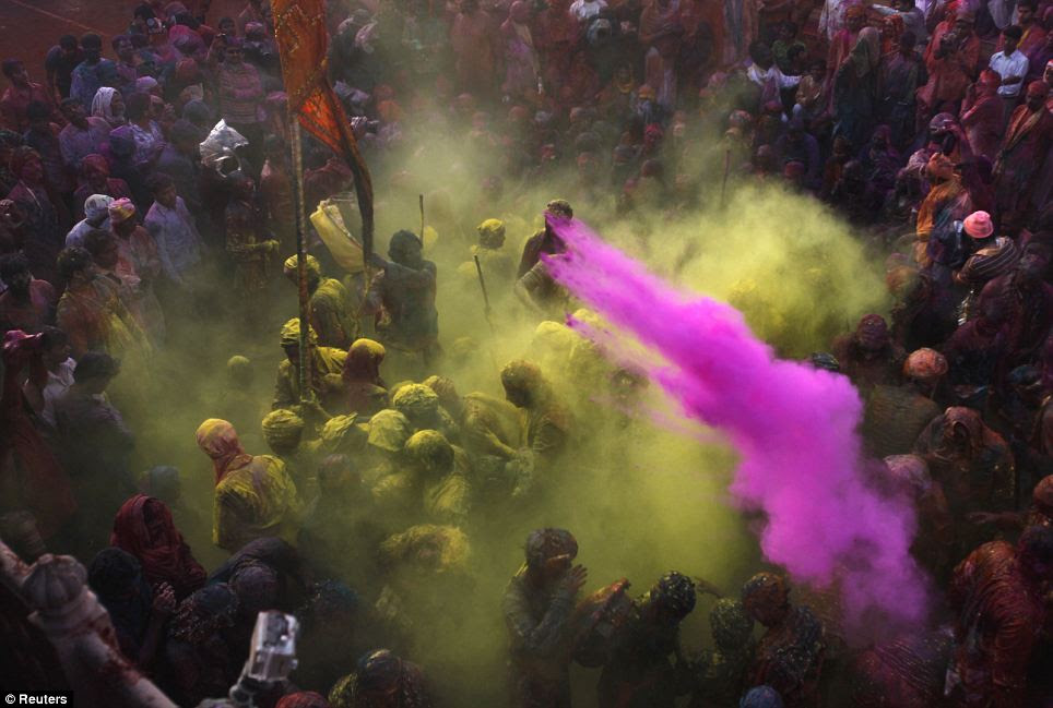 Vibrant: People throw coloured powder as they celebrate Lathmar Holi at Nandgaon village in the northern Indian state of Uttar Pradesh yesterday