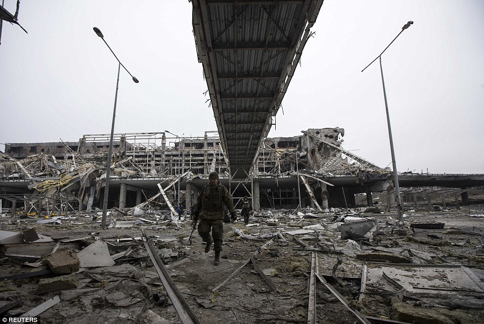 A rebel soldier wanders through part of Donetsk airport as artillery began withdrawing from the area