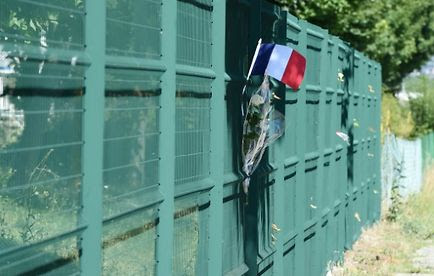 Un drapeau et des fleurs déposés le 28 juin 2015 à l'endroit où a été placée la tête de l'homme décapité à Saint-Quentin-Fallavier
