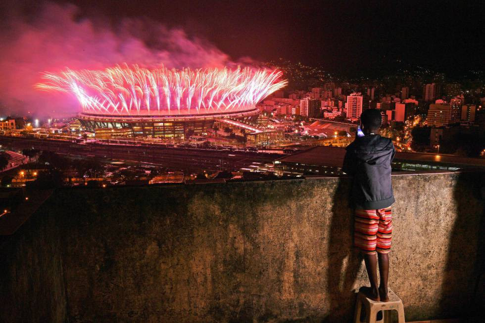 Menino assiste da comunidade da Mangueira a queima de fogos da cerimônia de encerramento da Olimpíada no Maracanã.