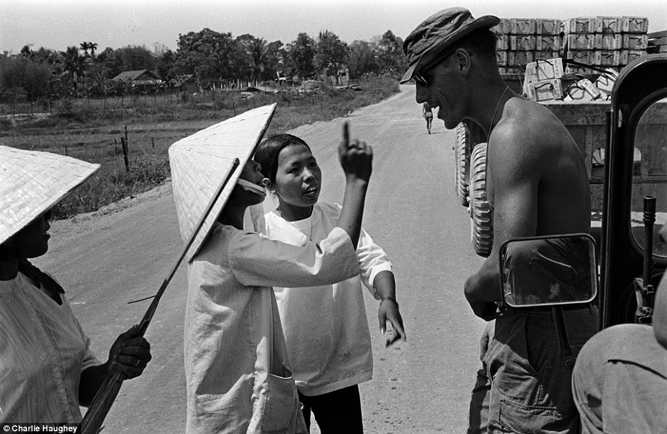 Community relations: A G.I. talks to Vietnamese natives on the road while escorting a supply convoy