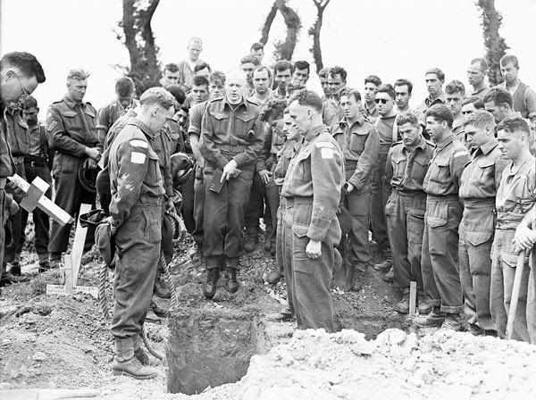 H Captain Callum Thompson, a Canadian chaplain, conducting a funeral service in the Normandy bridgehead, France, 16 July 1944.