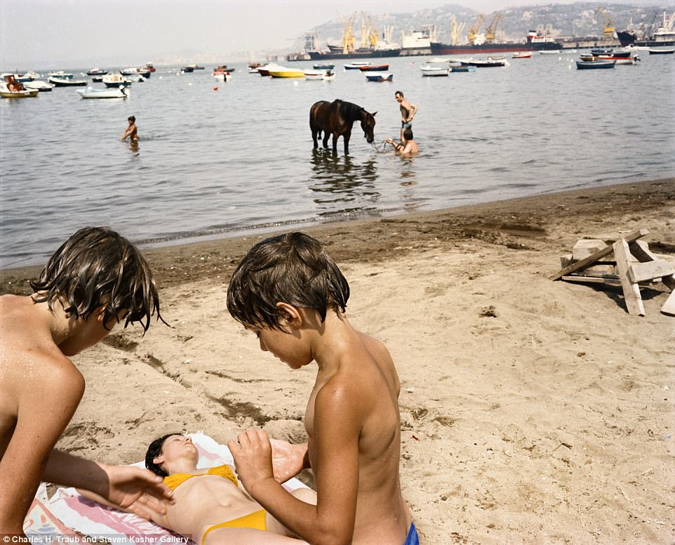 Mischief makers? Two young boys observe a woman asleep on the beach in Naples, 1982, while a horse is cooled off in the sea in the background