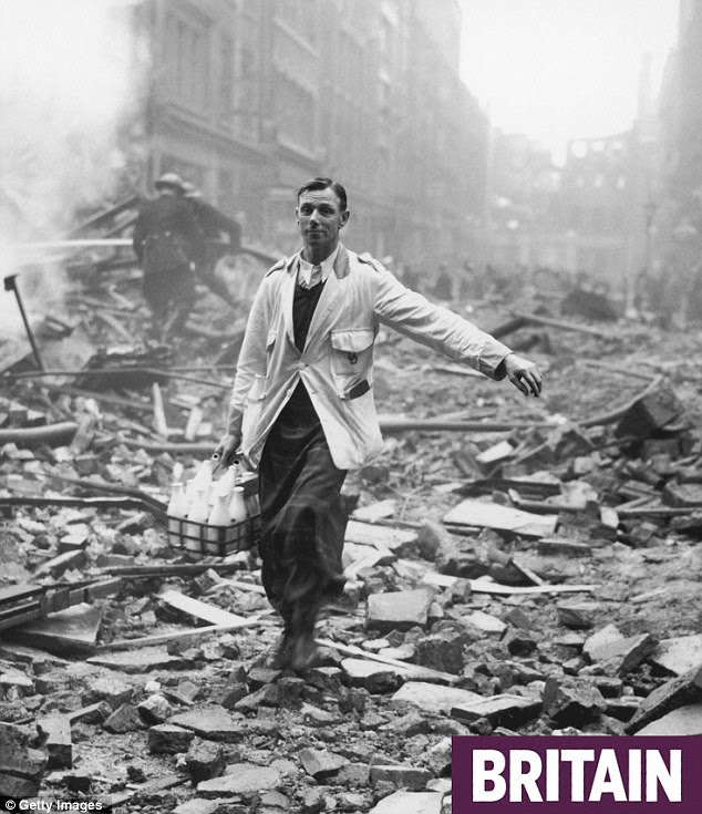 Pinta cheer: A milkman delivering milk in a London street devastated during a German bombing raid. Firemen are dampening down the ruins behind him