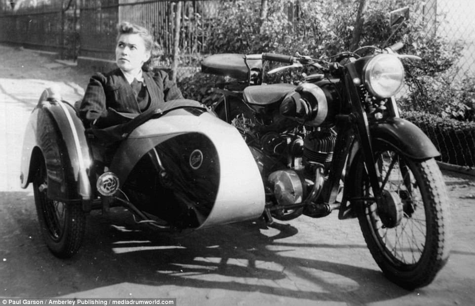 The allure of the motorbike in occupied lands is shown in this photo of a French woman sitting in a German sidecar