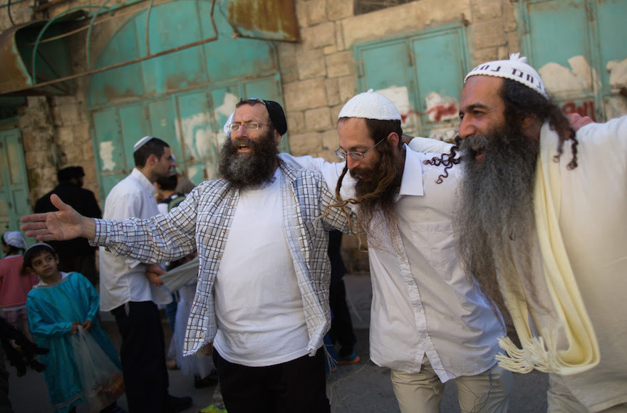 Right-wing activist Baruch Marzel dancing with jewish men during the annual parade marking the Jewish holiday of Purim in the divided West Bank town of Hebron, March 5, 2015. Photo by Yonatan Sindel/Flash90