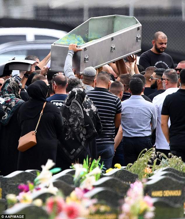 Mourners lift an empty coffin above their heads at the burial of Mick Hawi on Thursday