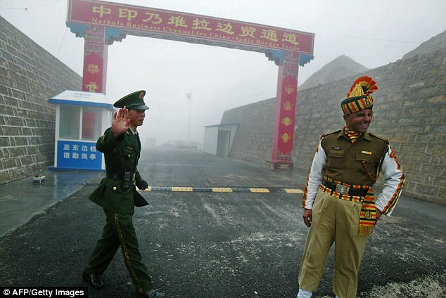 Chinese soldier (left) and an Indian soldier stand guard at the Chinese side of the ancient Nathu La border crossing between India and China