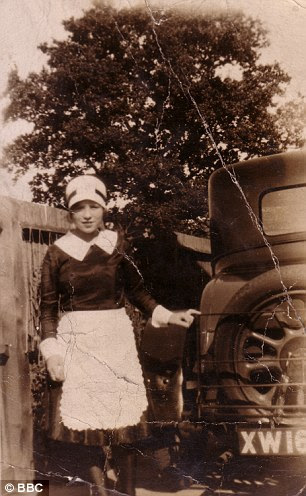 A servant posing beside a car in the late nineteenth century. 