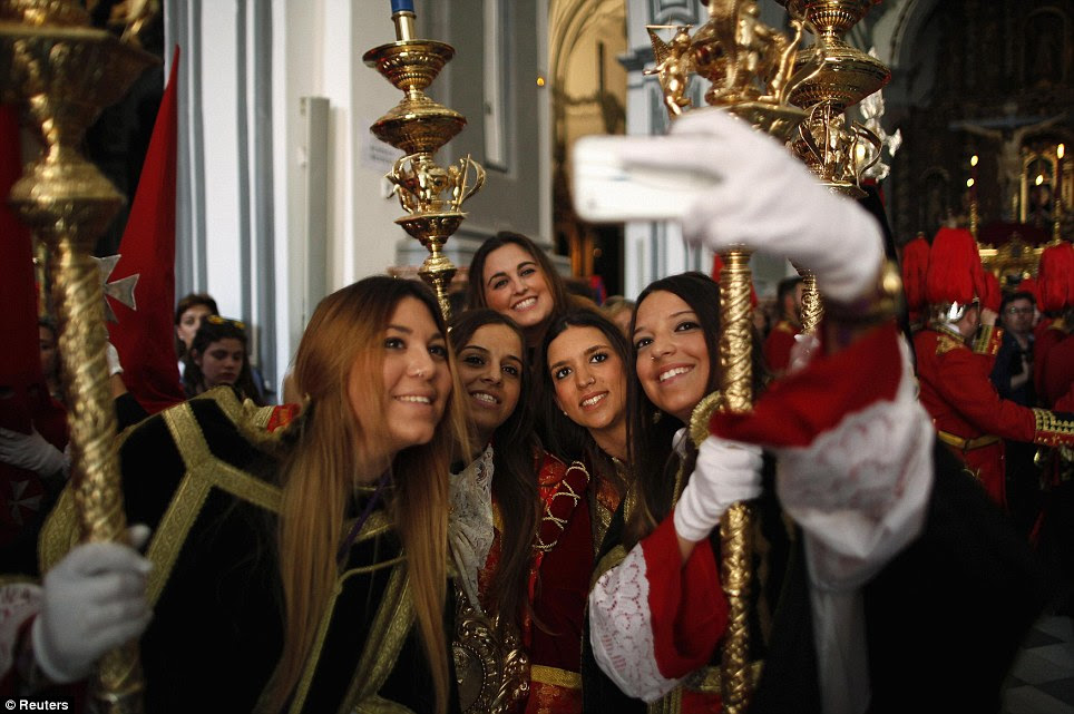 Church selfie: Penitents take their photos inside a church in Malaga, Spain, as part of Holy Week celebrations